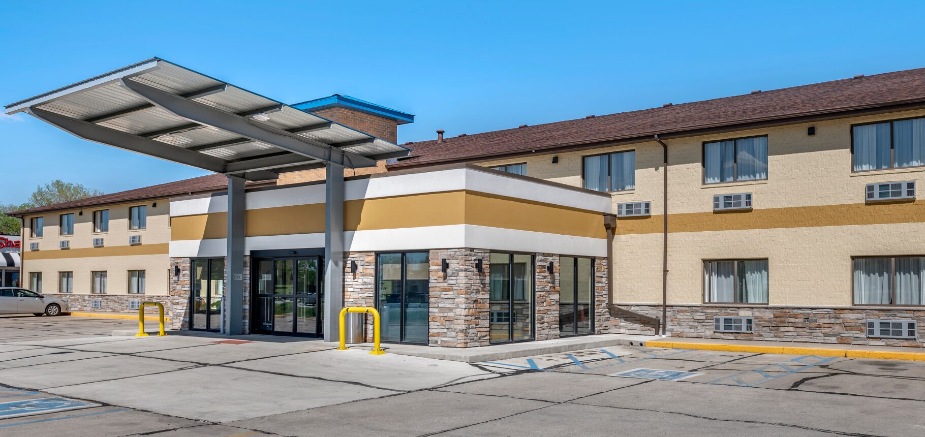Beige two-story motel with canopy entrance